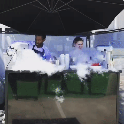 Woman in formal attire smiling while holding smoking mocktail drinks