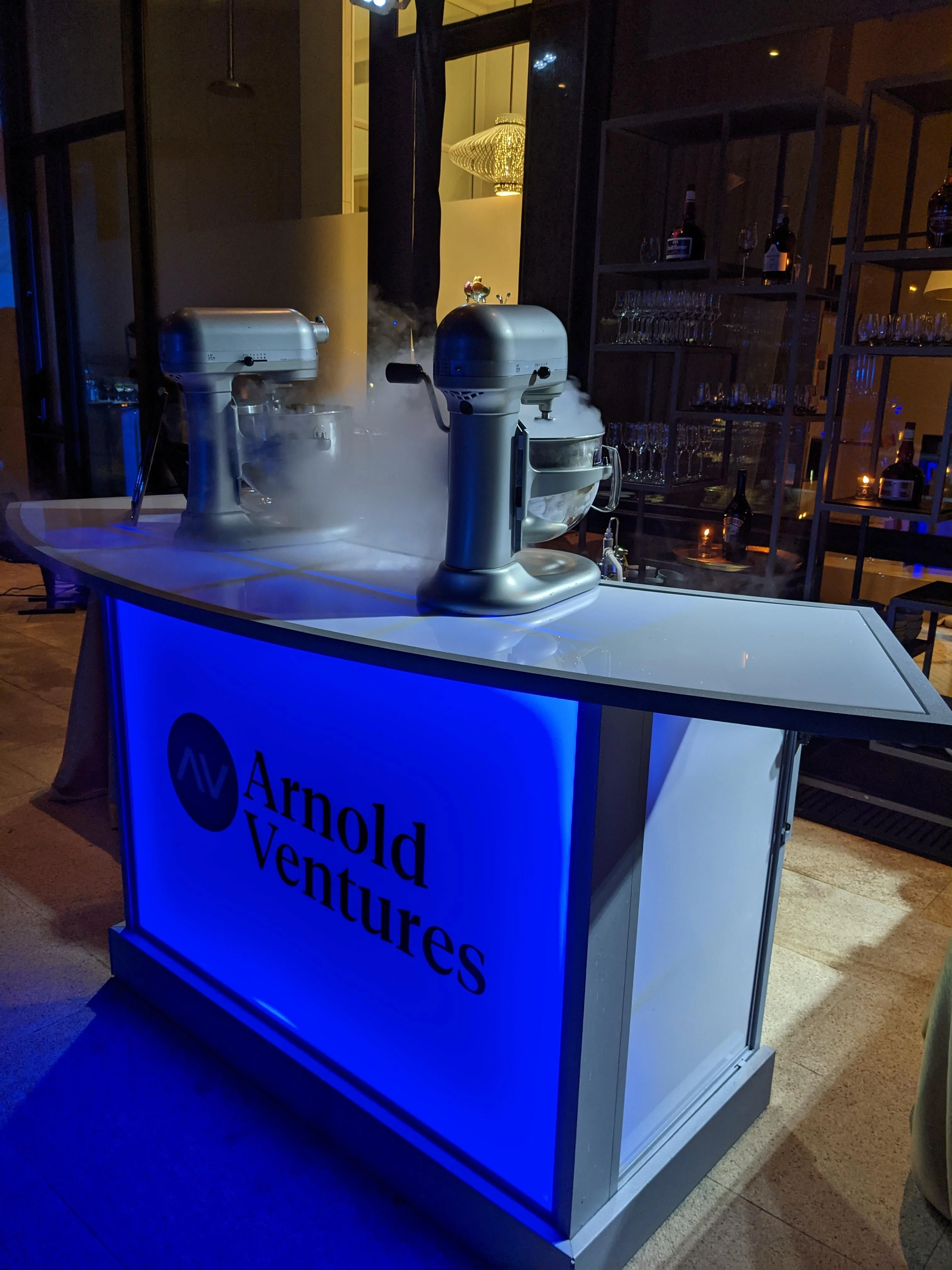 Logo Glow Bar brand activation: blue-lit portable LED light-up Glow Bar with a company logo and nitrogen ice cream mixers at a corporate event